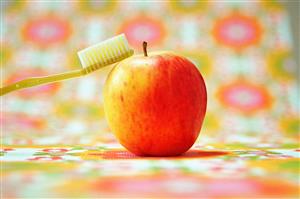 Toothbrush balancing on apple