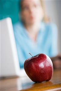 Teacher with an apple on her desk