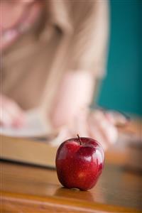 Teacher with an apple on her desk