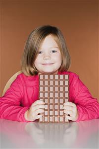 Girl holding a large bar of chocolate