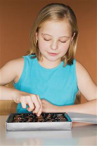 Girl picking a chocolate from the box