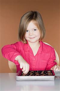 Girl taking a chocolate from the box